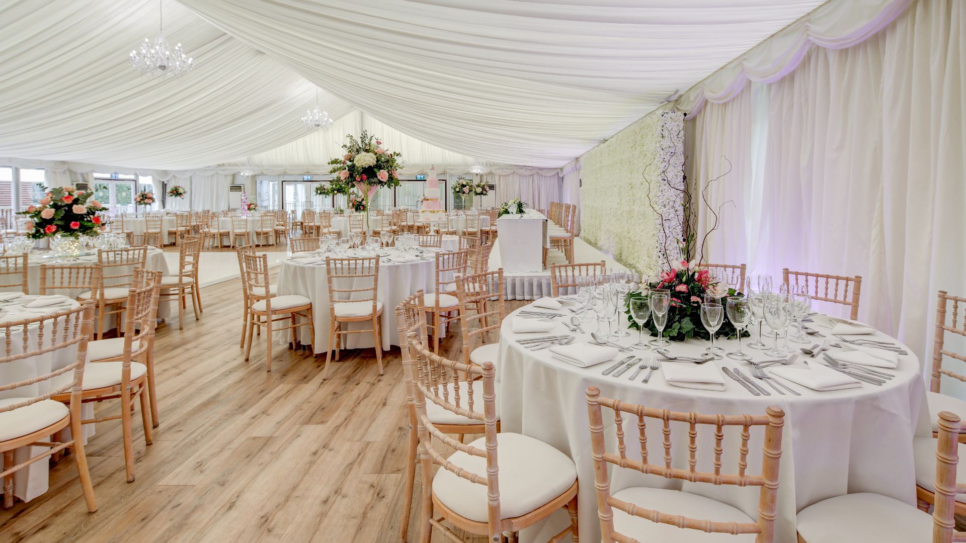 Tables in the Grand Pavilion set for dinner with floral centrepieces. 