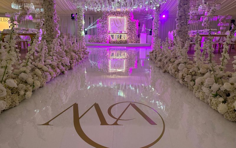 The Grand Pavilion decorated with a large dance floor and pink up lighting.