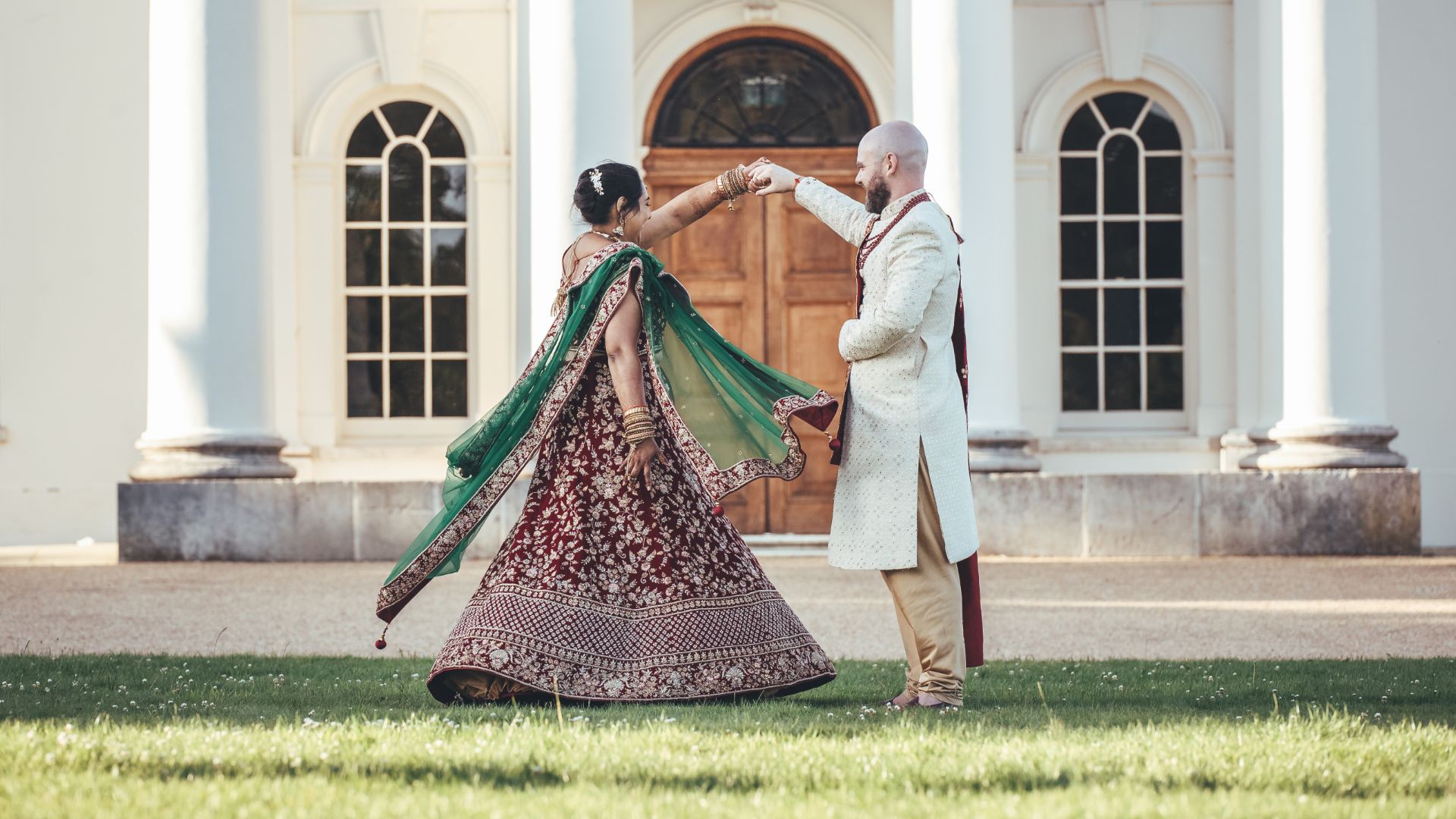 A groom dancing with his bride outside Hylands House. 