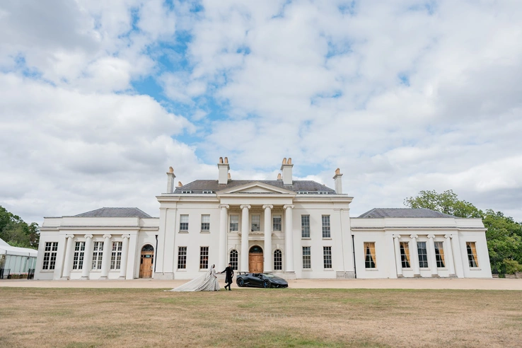 A couple walking hand-in-hand outside Hylands House. 